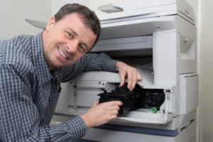 technicien r&eacute;parant un photocopieur 