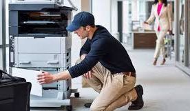 technicien r&eacute;parant un photocopieur 
